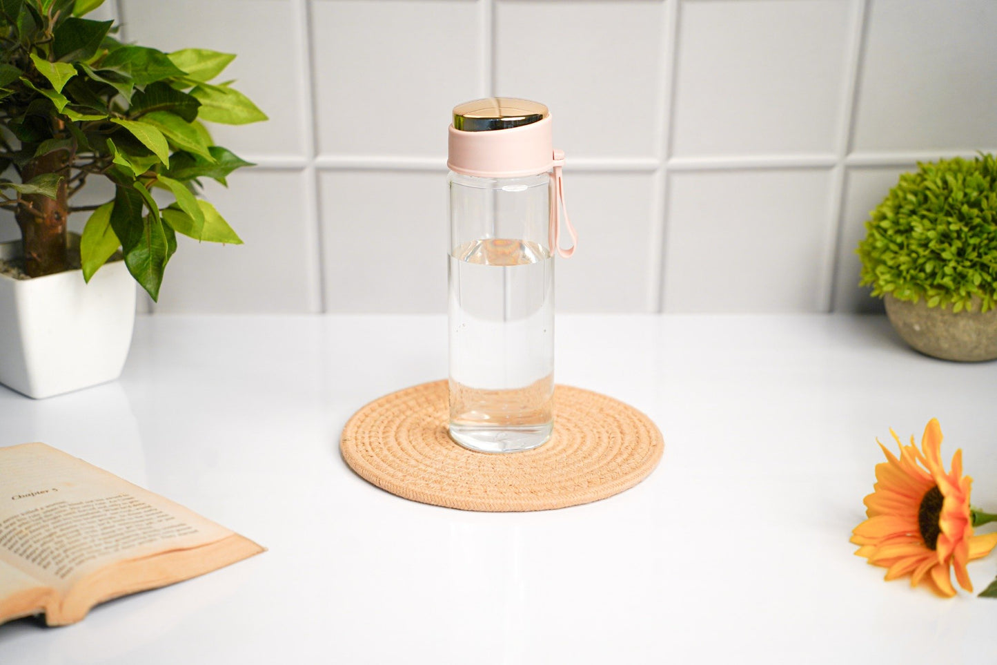 Glass water bottle with pink cap, eco-friendly and reusable