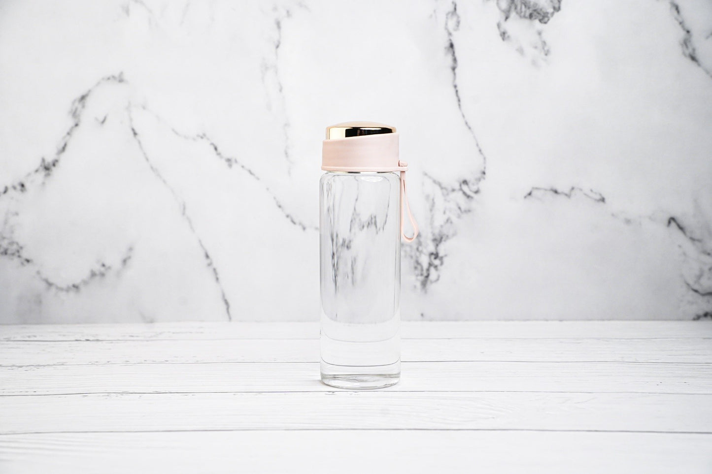 Glass water bottle with pink cap, eco-friendly and reusable
